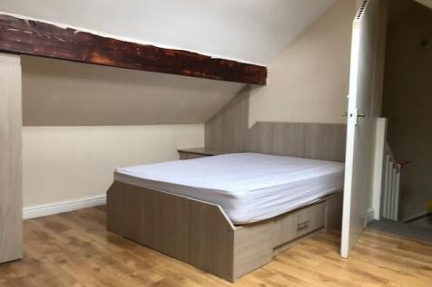 A cozy single bedroom with a comfortable bed an...