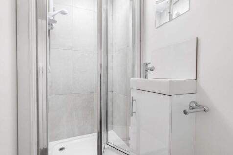 A modern, clean bathroom with a shower enclosur...