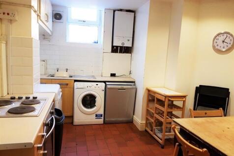 A well-lit kitchen area featuring basic applian...