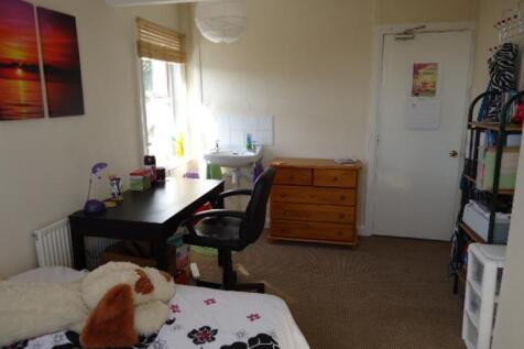 A cozy bedroom featuring a bed with a floral du...