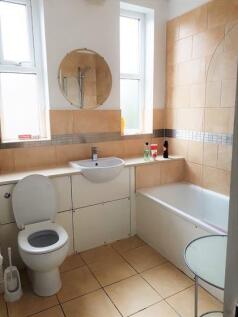 A clean and bright bathroom featuring a toilet,...