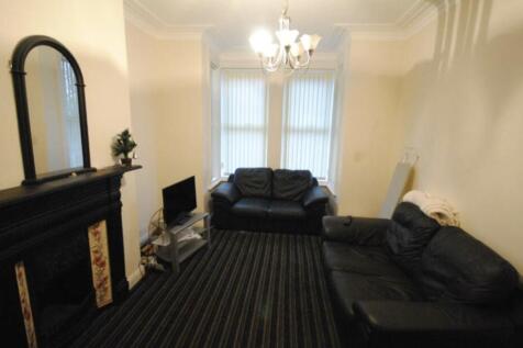 A spacious and well-lit living room featuring a...