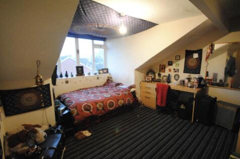 A spacious master bedroom featuring a comfortab...