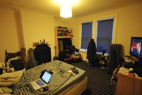 A well-lit living room featuring a comfortable ...