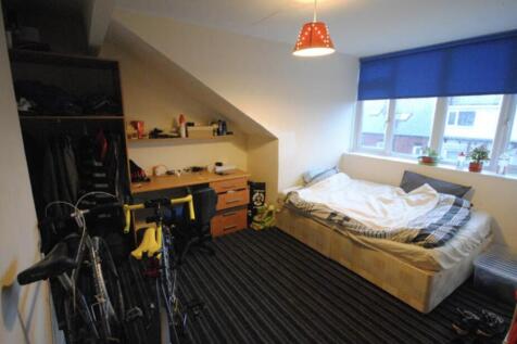 A cozy bedroom featuring a neatly made double b...