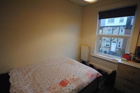 A cozy bedroom featuring a double bed beneath a...
