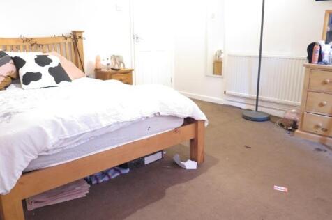 A tidy bedroom featuring a comfortable wooden b...