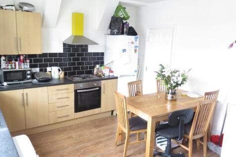 A bright and modern kitchen with light wooden c...
