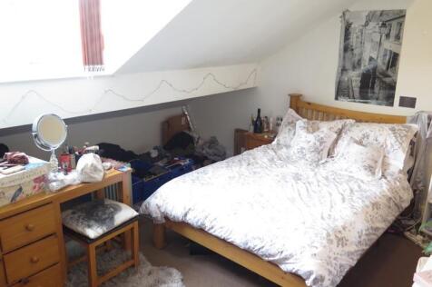 A cozy bedroom featuring a double bed with patt...