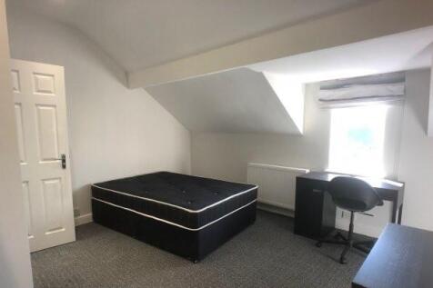 A spacious and well-lit bedroom featuring a lar...