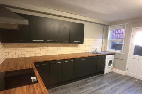 A modern kitchen featuring sleek dark cabinets,...