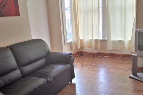 A spacious and well-lit living room featuring a...