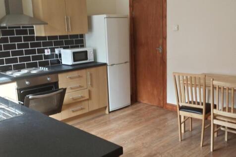 A modern kitchen area featuring wooden cabinets...