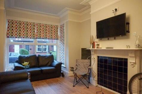 A spacious and well-lit living room featuring c...