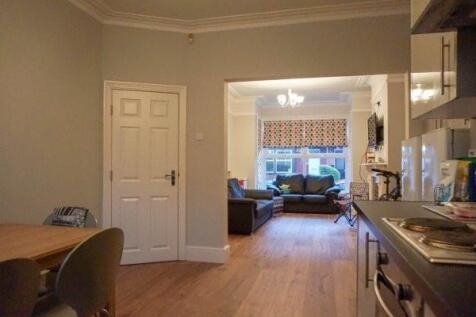 A spacious, bright living room with large windo...