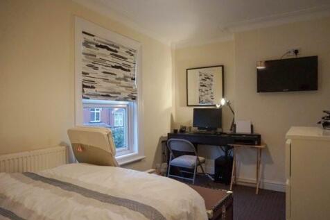A well-lit, tidy living room featuring a comfor...