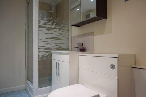 Modern bathroom with glass shower enclosure and...