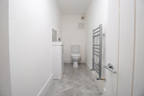 A clean, modern bathroom featuring a toilet and...