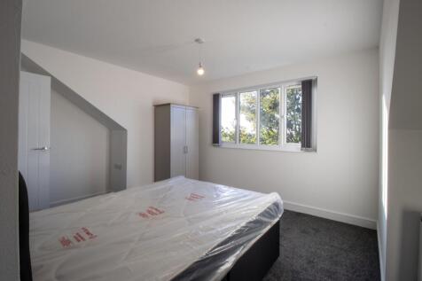 A bright and tidy bedroom with a large window l...