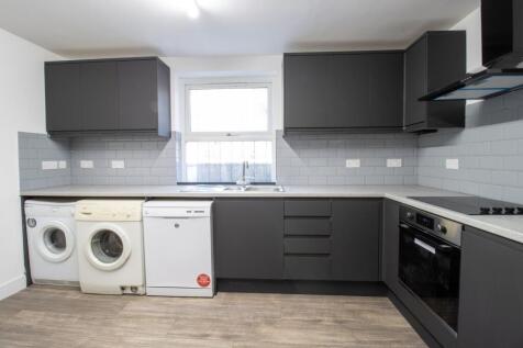 Modern galley kitchen with dark grey cabinets, ...