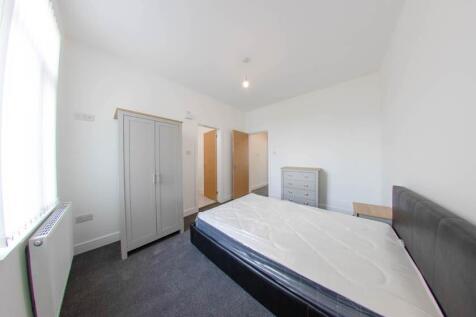 A spacious, well-lit master bedroom featuring a...