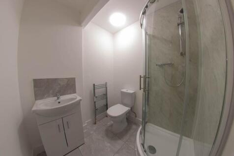 Bright and clean bathroom featuring a shower en...