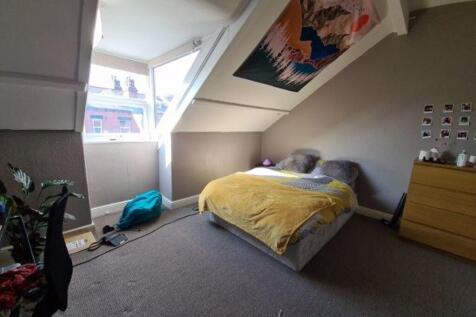 A cozy and well-lit bedroom featuring a double ...