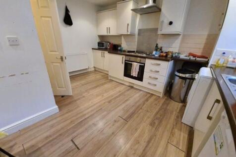 A well-lit, modern kitchen with white cabinets ...