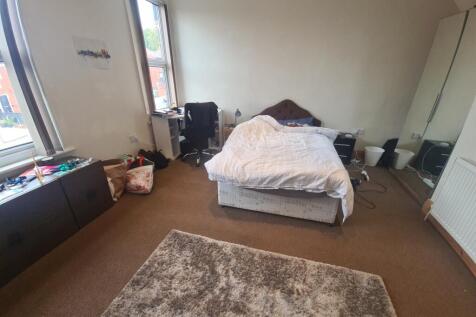 A cozy bedroom featuring a double bed with a pl...