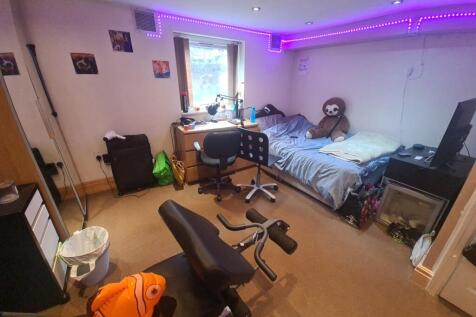 A cozy bedroom featuring a large bed, a study d...