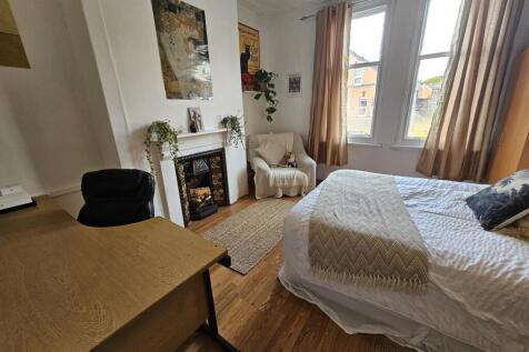 A cozy double bedroom featuring a neatly made b...