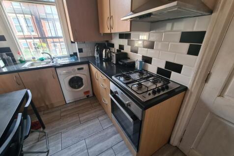 A modern kitchen with wooden cabinets, black co...