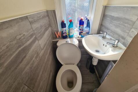 A compact bathroom featuring a toilet and a sma...