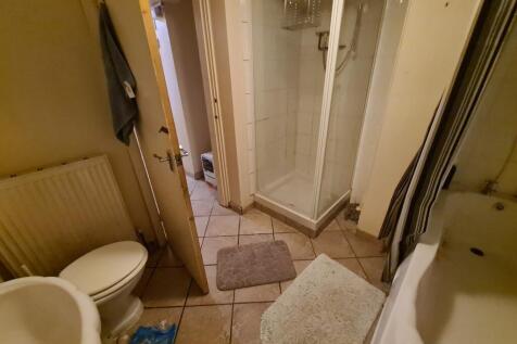 A clean and well-lit bathroom featuring a large...