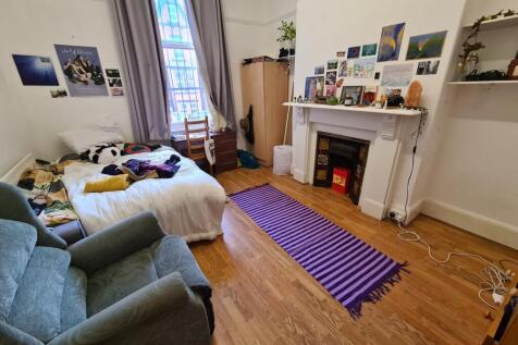 A cozy living room featuring a blue armchair, a...