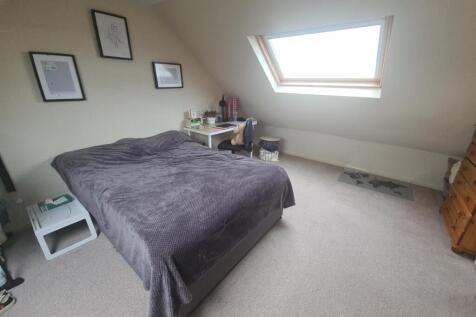 A bright, spacious master bedroom featuring a l...