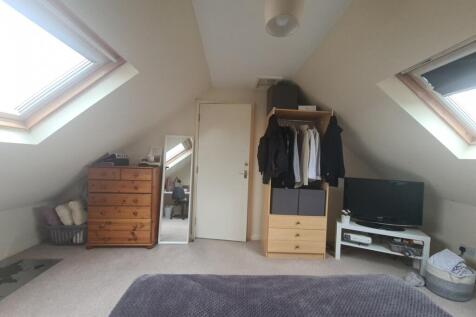 A cozy attic bedroom with skylight windows prov...