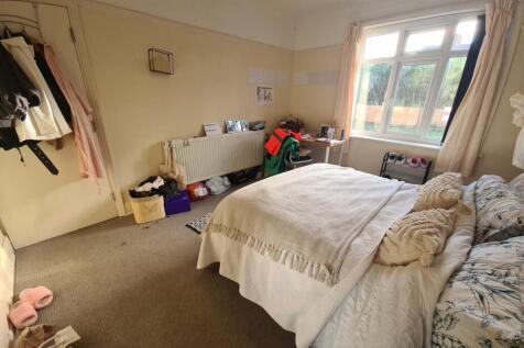 A well-lit bedroom featuring a comfortable doub...