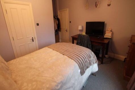 A cozy bedroom featuring a large bed with a com...