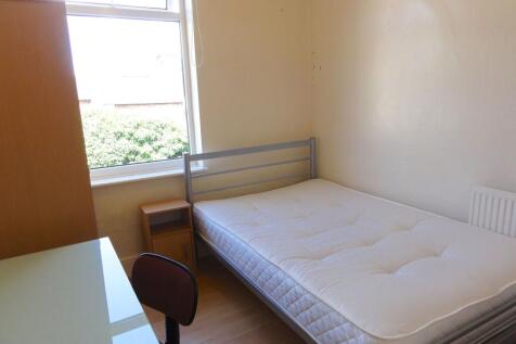 A cozy bedroom featuring a single bed positione...