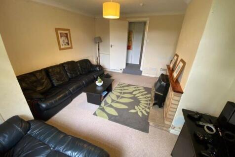 A spacious and well-lit living room featuring c...