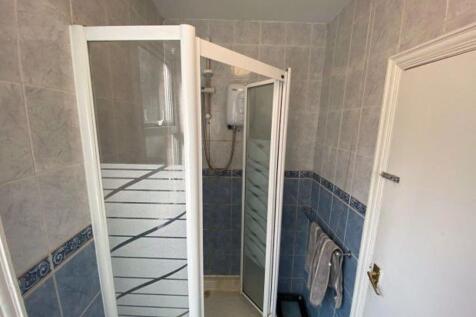 A spacious bathroom with a large shower unit, m...