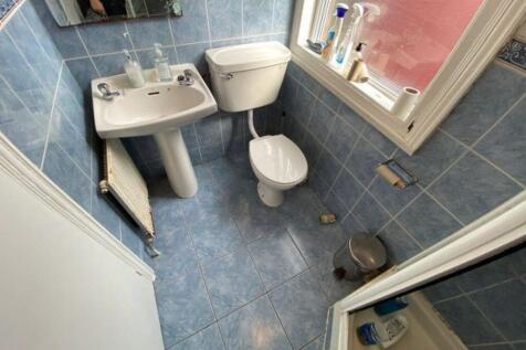 A tidy bathroom featuring a toilet, sink, and w...