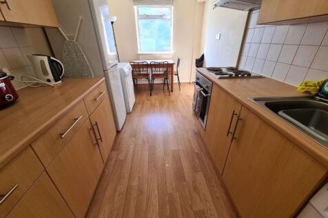 Bright and tidy kitchen with wooden cabinetry a...