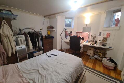 A cozy bedroom with a neatly made bed, a window...