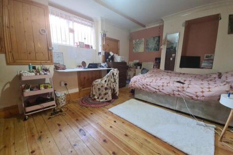 A cozy bedroom with a comfortable bed, wooden f...