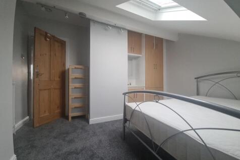 A bright and airy attic bedroom featuring a met...