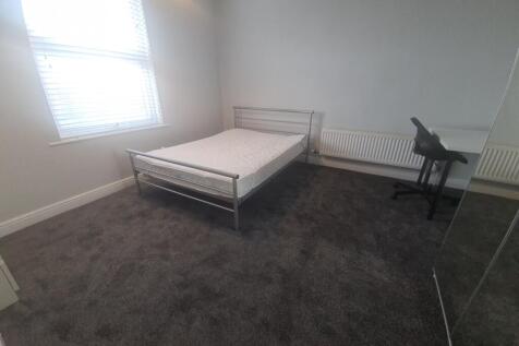 A simple, clean, well-lit bedroom with a single...