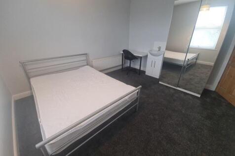 A tidy and straightforward bedroom featuring a ...