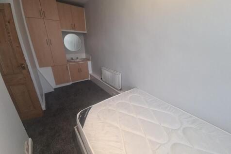 A modestly sized bedroom with a single bed and ...